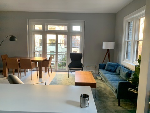 Open living and dining space with a sofa, table, and clear path