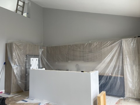 Kitchen under renovation with protective covering over cabinets